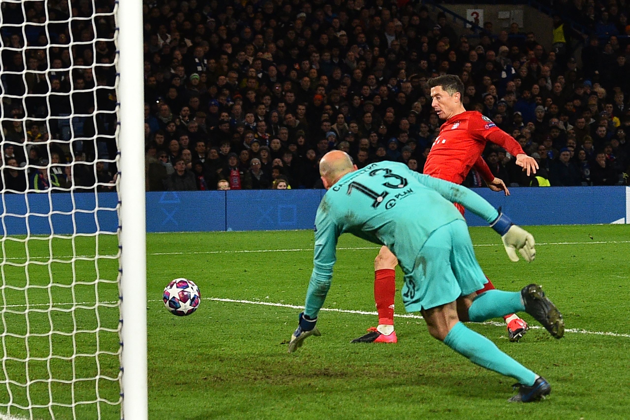 Bayern Munich's Polish striker Robert Lewandowski scores their third goal past Chelsea's Argentinian goalkeeper Willy Caballero during the UEFA Champion's League round of 16 first leg football match between Chelsea and Bayern Munich at Stamford Bridge in 