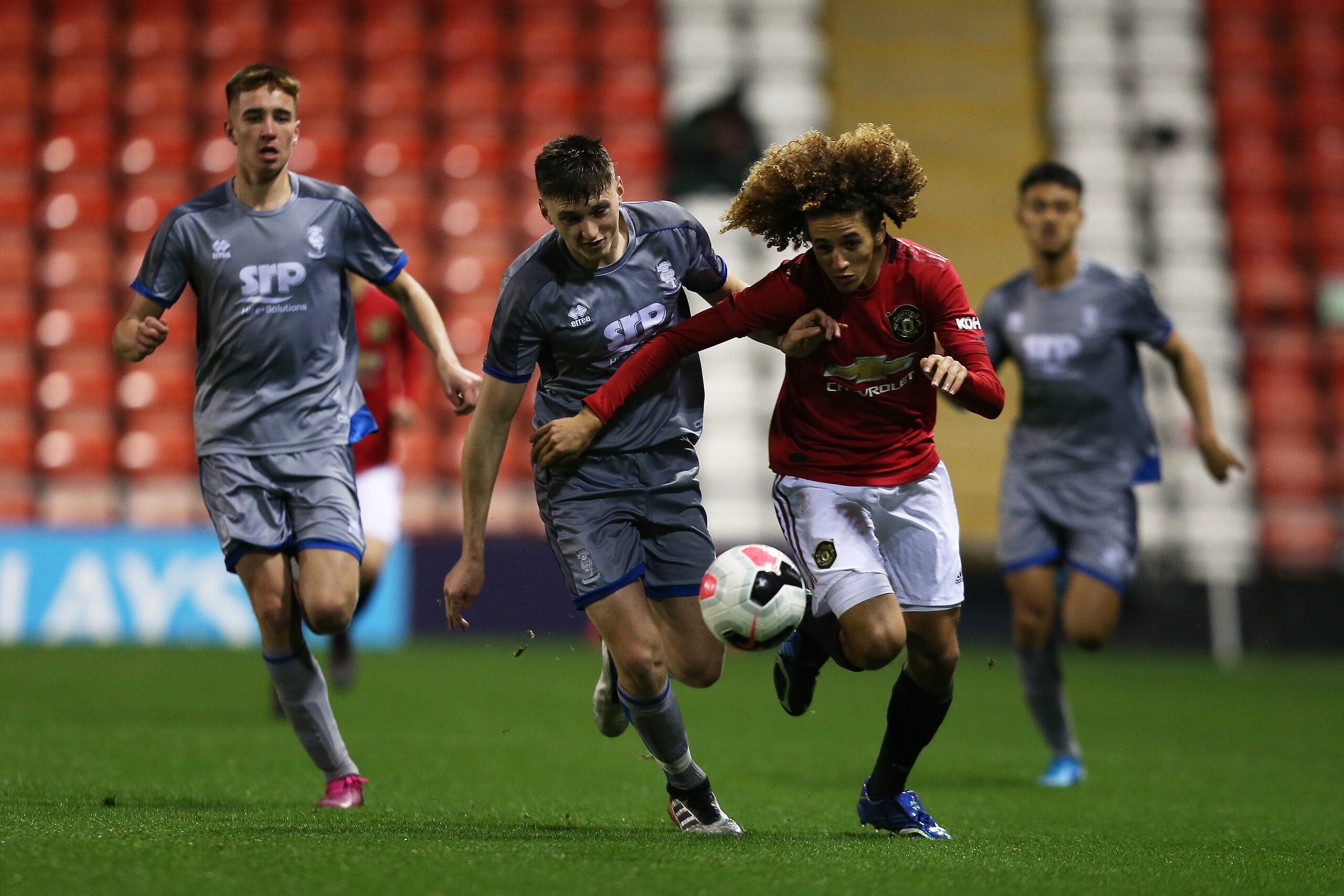 LEIGH, ENGLAND - DECEMBER 13: Haydn Tear of Lincoln City and Hannibal Mejbri of Manchester United go for the ball during the FA Youth Cup Third Round match between Manchester United and Lincoln City at Leigh Sports Village on December 13, 2019 in Leigh, E