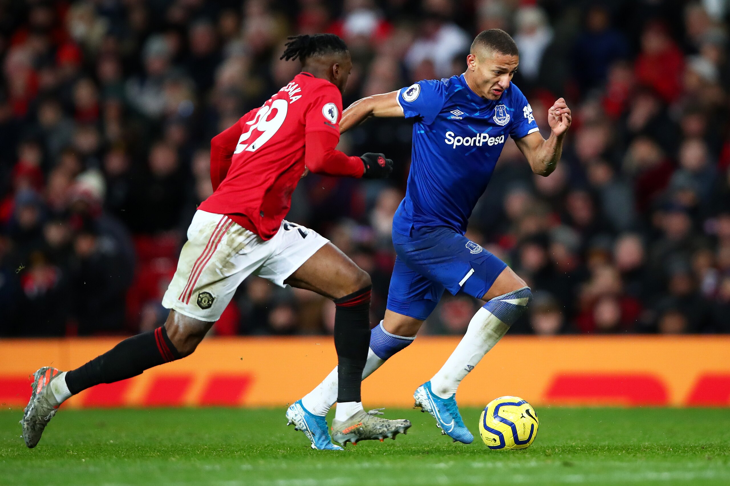 MANCHESTER, ENGLAND - DECEMBER 15: Richarlison of Everton is challenged by Aaron Wan-Bissaka of Manchester United during the Premier League match between Manchester United and Everton FC at Old Trafford on December 15, 2019 in Manchester, United Kingdom. 