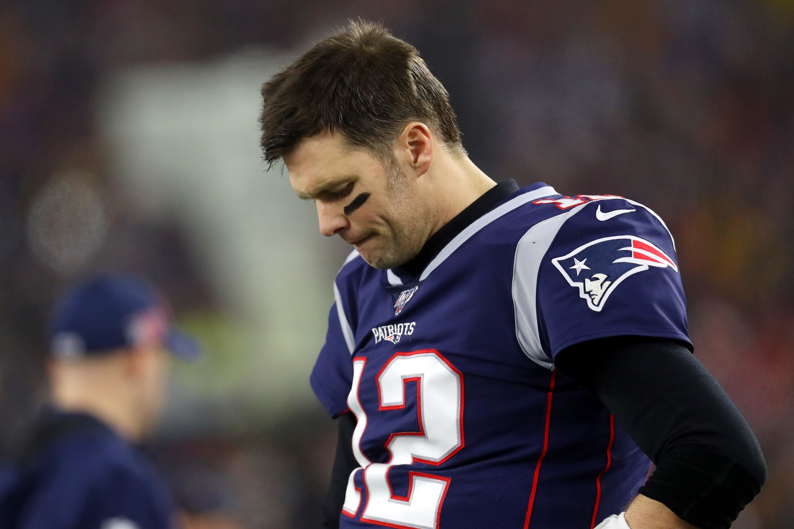FOXBOROUGH, MASSACHUSETTS - JANUARY 04: Tom Brady #12 of the New England Patriots looks on from the sideline during the the AFC Wild Card Playoff game against the Tennessee Titans at Gillette Stadium on January 04, 2020 in Foxborough, Massachusetts. (Phot FOXBOROUGH, MASSACHUSETTS - JANUARY 04: Tom Brady #12 of the New England Patriots looks on from the sideline during the the AFC Wild Card Playoff game against the Tennessee Titans at Gillette Stadium on January 04, 2020 in Foxborough, Massachusetts. (Phot