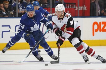 TORONTO, ON - FEBRUARY 11:  Taylor Hall #91 of the Arizona Coyotes skates with the puck against Kasperi Kapanen #24 of the Toronto Maple Leafs during an NHL game at Scotiabank Arena on February 11, 2020 in Toronto, Ontario, Canada. The Maple Leafs defeate