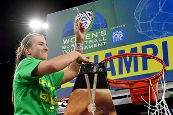LAS VEGAS, NEVADA - MARCH 08:  Sabrina Ionescu #20 of the Oregon Ducks cuts down a net after the team defeated the Stanford Cardinal 89-56 to win the championship game of the Pac-12 Conference women's basketball tournament at the Mandalay Bay Events Cente