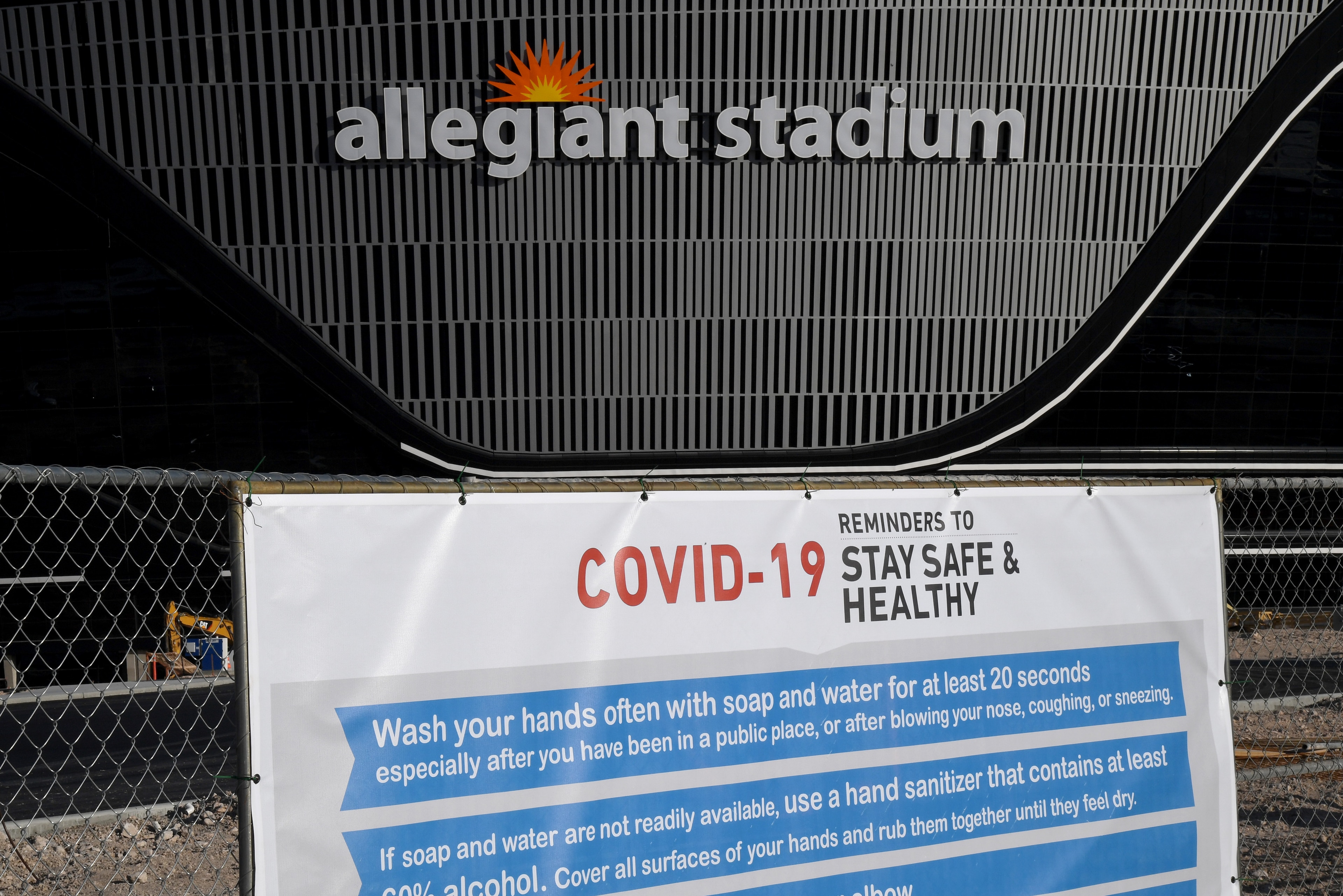 LAS VEGAS, NEVADA - APRIL 03:  A sign with guidelines for how to stay safe from the coronavirus is posted on a fence at Allegiant Stadium as construction continues on the USD 2 billion, glass-domed future home of the Las Vegas Raiders on April 3, 2020 in 