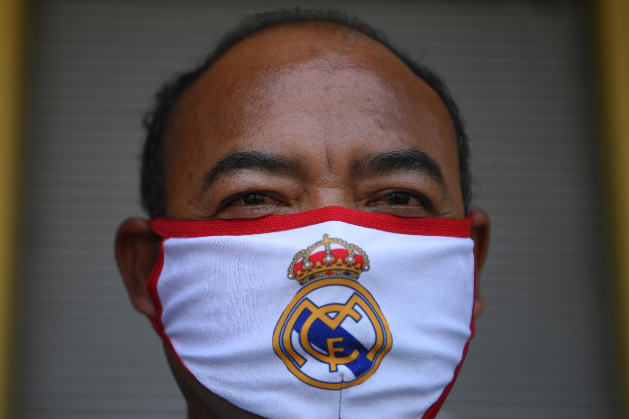A man wears a protective mask with the emblem of Spanish football club Real Madrid against the spread of the new coronavirus in San Salvador, on April 11, 2020. (Photo by MARVIN RECINOS / AFP) (Photo by MARVIN RECINOS/AFP via Getty Images) A man wears a protective mask with the emblem of Spanish football club Real Madrid against the spread of the new coronavirus in San Salvador, on April 11, 2020. (Photo by MARVIN RECINOS / AFP) (Photo by MARVIN RECINOS/AFP via Getty Images)