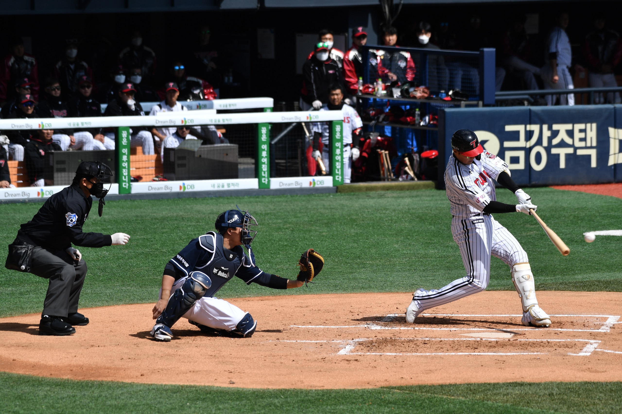 LG Twins' Chae Eun-seong (R) hits a ball during a pre-season baseball game between Seoul-based Doosan Bears and LG Twins at Jamsil stadium in Seoul on April 21, 2020. - Professional sport returned to South Korea on April 21 as coronavirus restrictions eas
