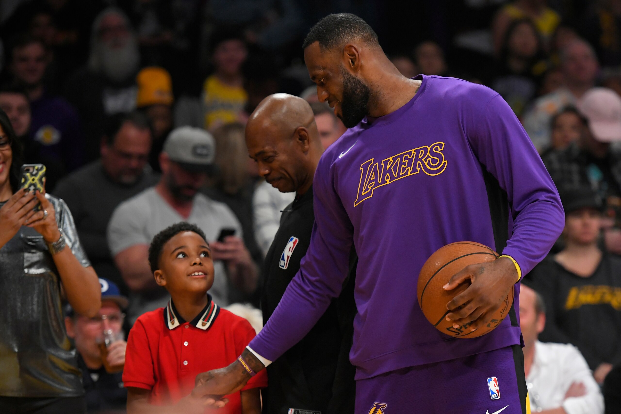 LOS ANGELES, CA - JANUARY 01: LeBron James #23 of the Los Angeles Lakers with a young fan before playing the Phoenix Suns at Staples Center on January 1, 2020 in Los Angeles, California. NOTE TO USER: User expressly acknowledges and agrees that, by downlo
