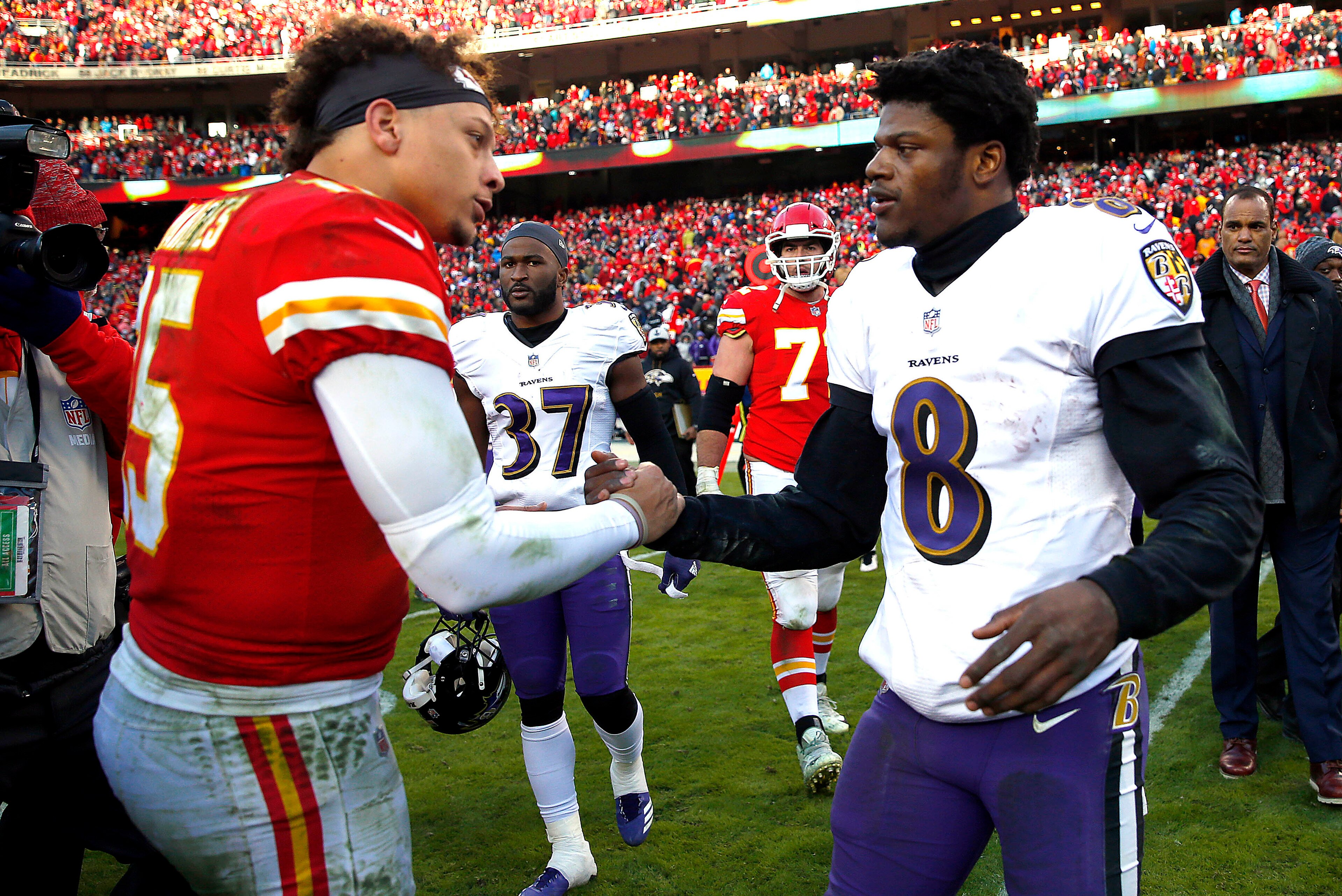 KANSAS CITY, MISSOURI - DECEMBER 09:  Quarterback Patrick Mahomes #15 of the Kansas City Chiefs shakes hands with quarterback Lamar Jackson #8 of the Baltimore Ravens after the Chiefs defeated the Ravens 27-24 in overtime to win the game at Arrowhead Stad