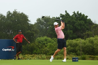 HOBE SOUND, FLORIDA - MAY 24: Former NFL player Peyton Manning plays his shot from the first tee as Tiger Woods looks on during The Match: Champions For Charity at Medalist Golf Club on May 24, 2020 in Hobe Sound, Florida. (Photo by Mike Ehrmann/Getty Ima
