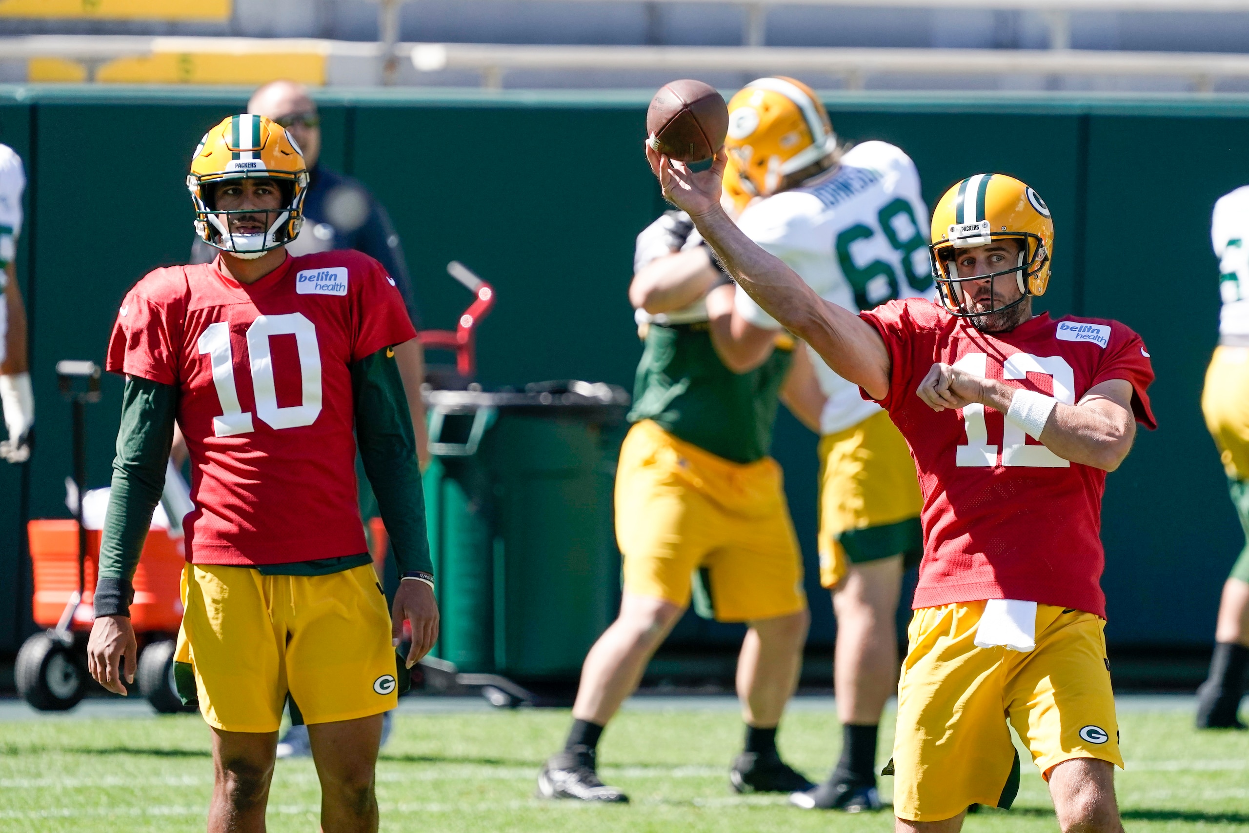 Aaron Rodgers throwing, with Jordan Love looking on. Aaron Rodgers throwing, with Jordan Love looking on.