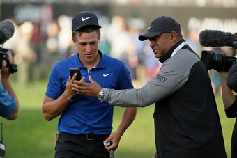 Jeff Champ hands off a phone to Cam so he can talk to his grandfather, Mack, after Cam won the Safeway Open in September 2019.