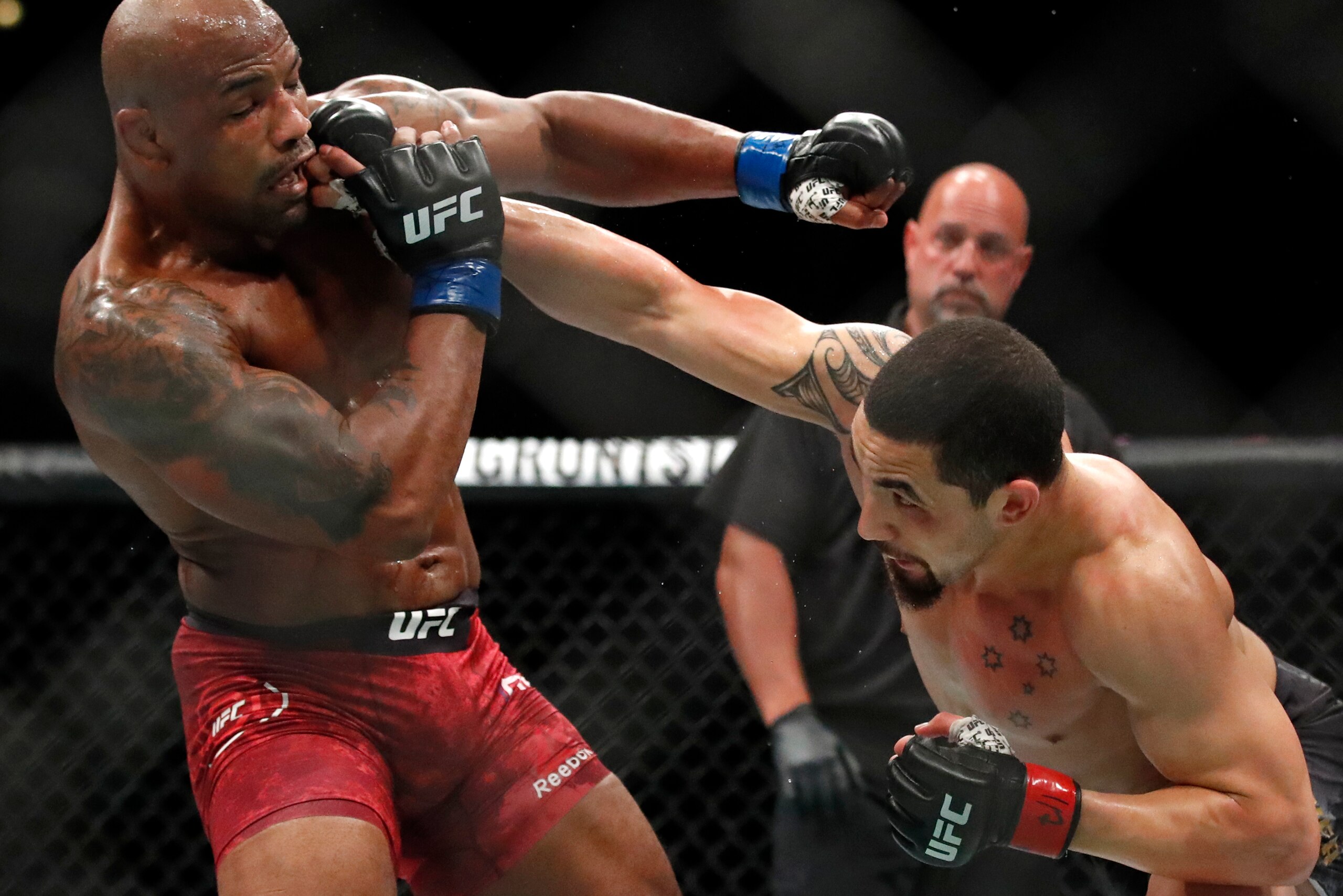 Robert Whittaker (right) punches Yoel Romero in 2018