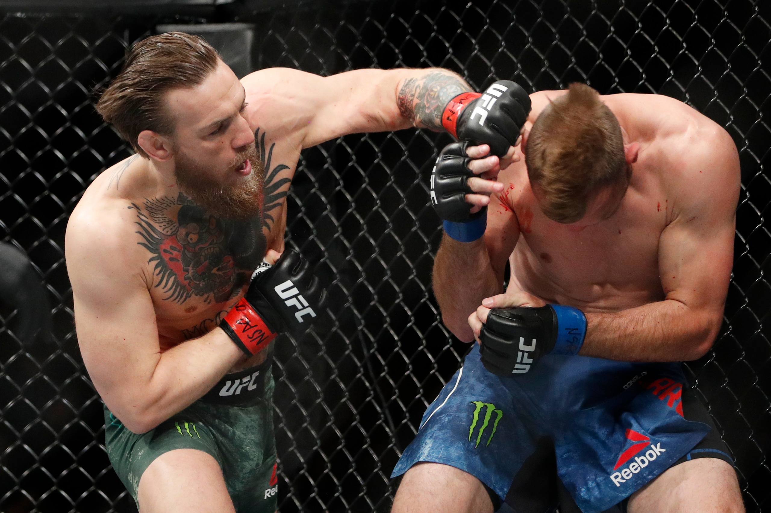 Conor McGregor (left) punches Donald Cerrone
