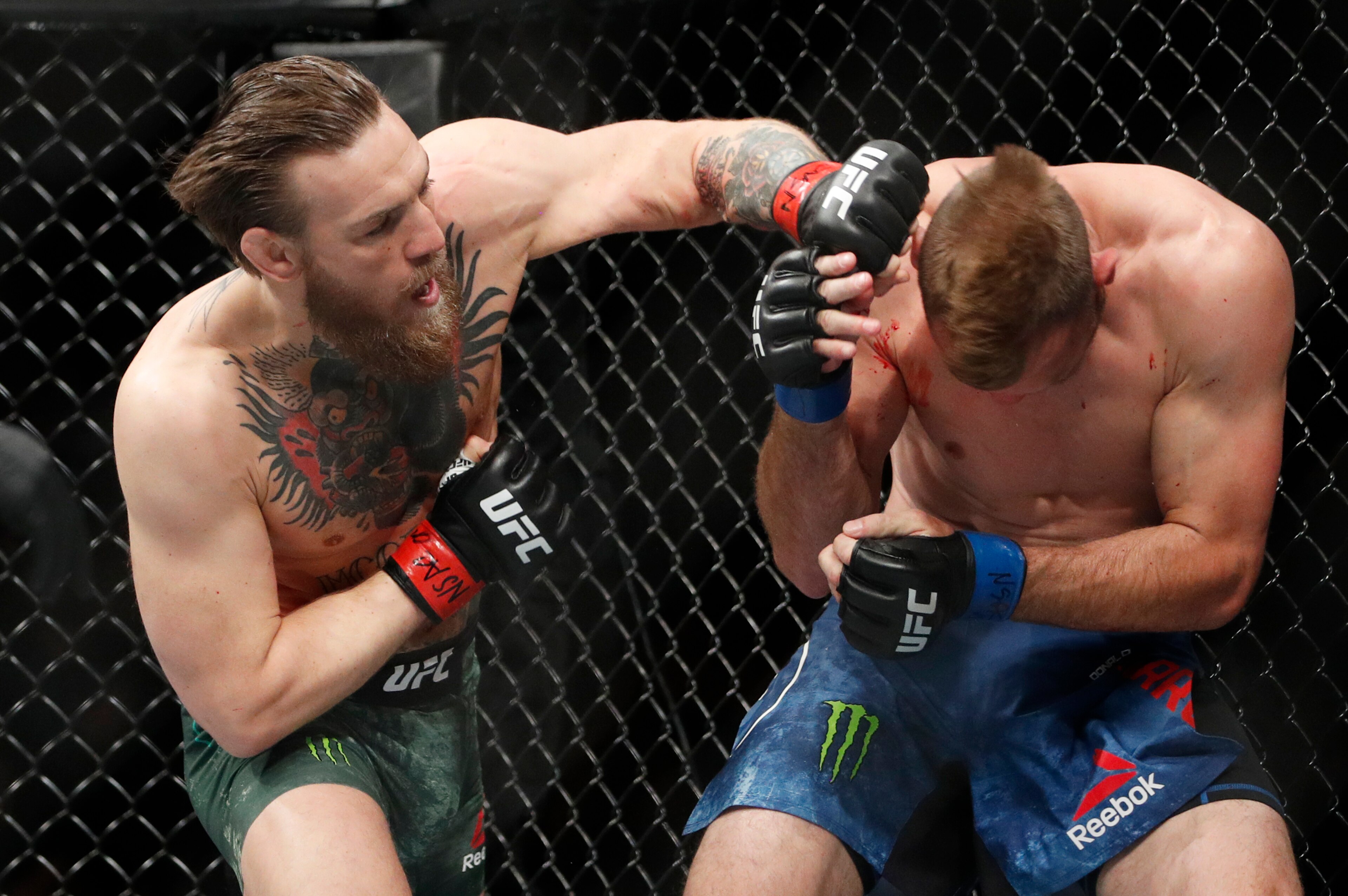Conor McGregor (left) punches Donald Cerrone