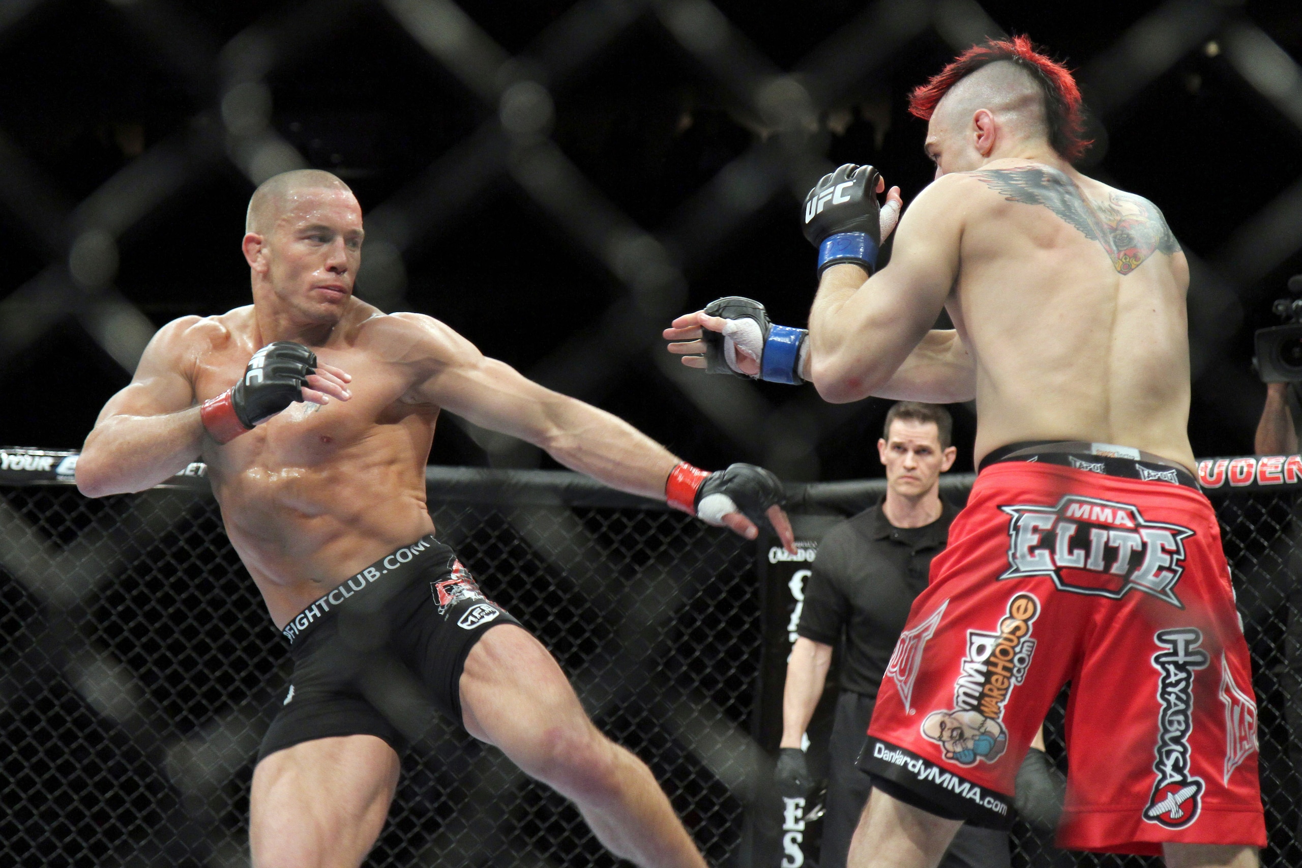 Georges St-Pierre (left) throws a kick, which aren't allowed in boxing