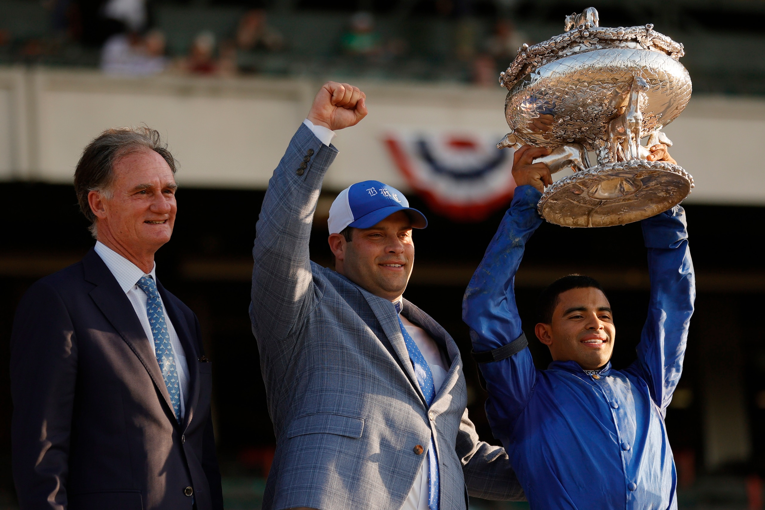 ELMONT, NEW YORK - JUNE 05: President of Godolphin Stables Jimmy Bell, trainer Brad H. Cox, and jockey Luis Saez celebrate with the trophy after Essential Quality wins the 153rd running of the Belmont Stakes at Belmont Park on June 05, 2021 in Elmont, New