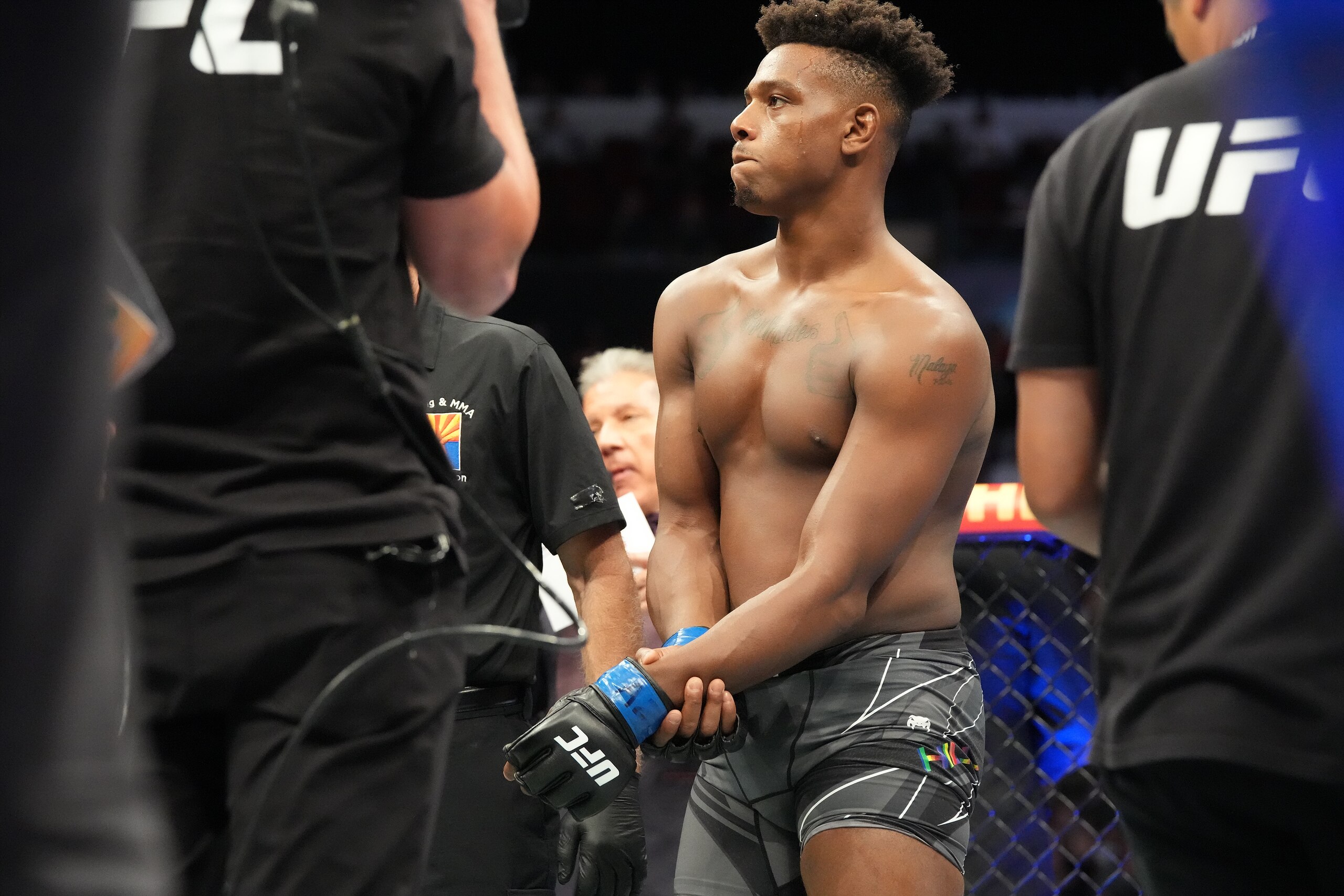 GLENDALE, AZ - JUNE 12: Jamahal Hill (blue gloves)  receives medical attention after breaking his arm in the octagon during UFC 263 on June 12, 2021, at Gila River Arena in Glendale, AZ. (Photo by Louis Grasse/PxImages/Icon Sportswire via Getty Images)