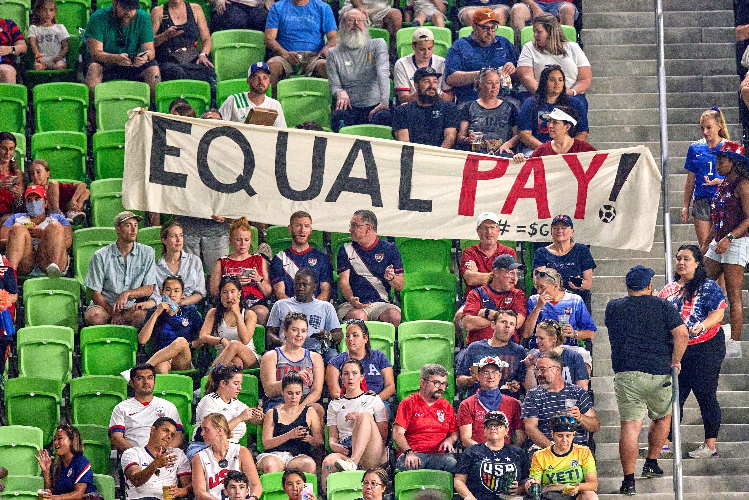 AUSTIN, TX - JUNE 16: United States fans hold up an Equal Pay banner in protest of unequal wages for female athletes in action during a Summer Series friendly international match between Nigeria and the United States on June 16, 2021 at Q2 Stadium in Aust AUSTIN, TX - JUNE 16: United States fans hold up an Equal Pay banner in protest of unequal wages for female athletes in action during a Summer Series friendly international match between Nigeria and the United States on June 16, 2021 at Q2 Stadium in Aust