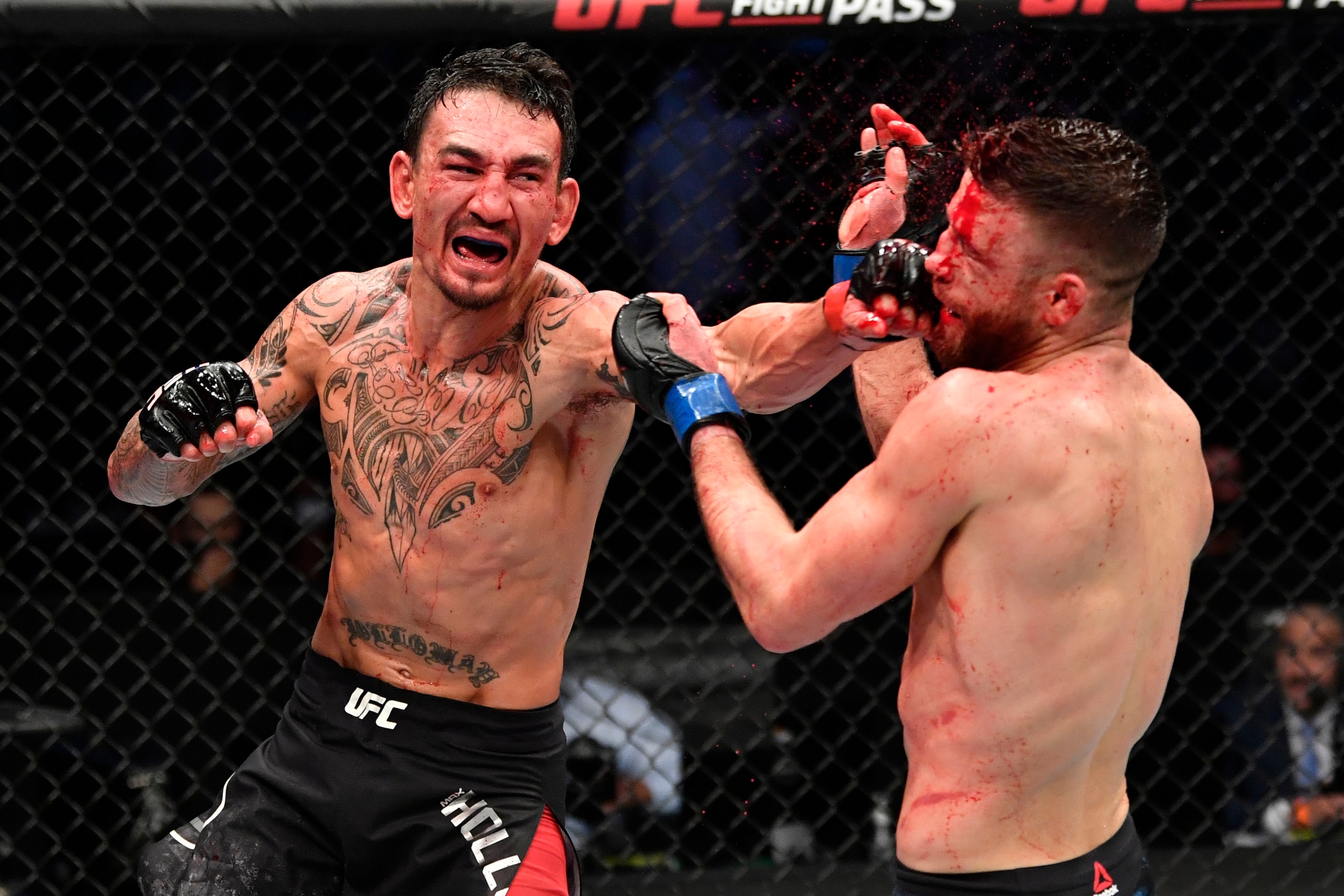 ABU DHABI, UNITED ARAB EMIRATES - JANUARY 17: (L-R) Max Holloway punches Calvin Kattar in a featherweight bout during the UFC Fight Night event at Etihad Arena on UFC Fight Island on January 17, 2021 in Abu Dhabi, United Arab Emirates. (Photo by Jeff Bott