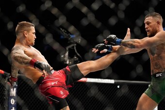 Dustin Poirier (left) kicks McGregor