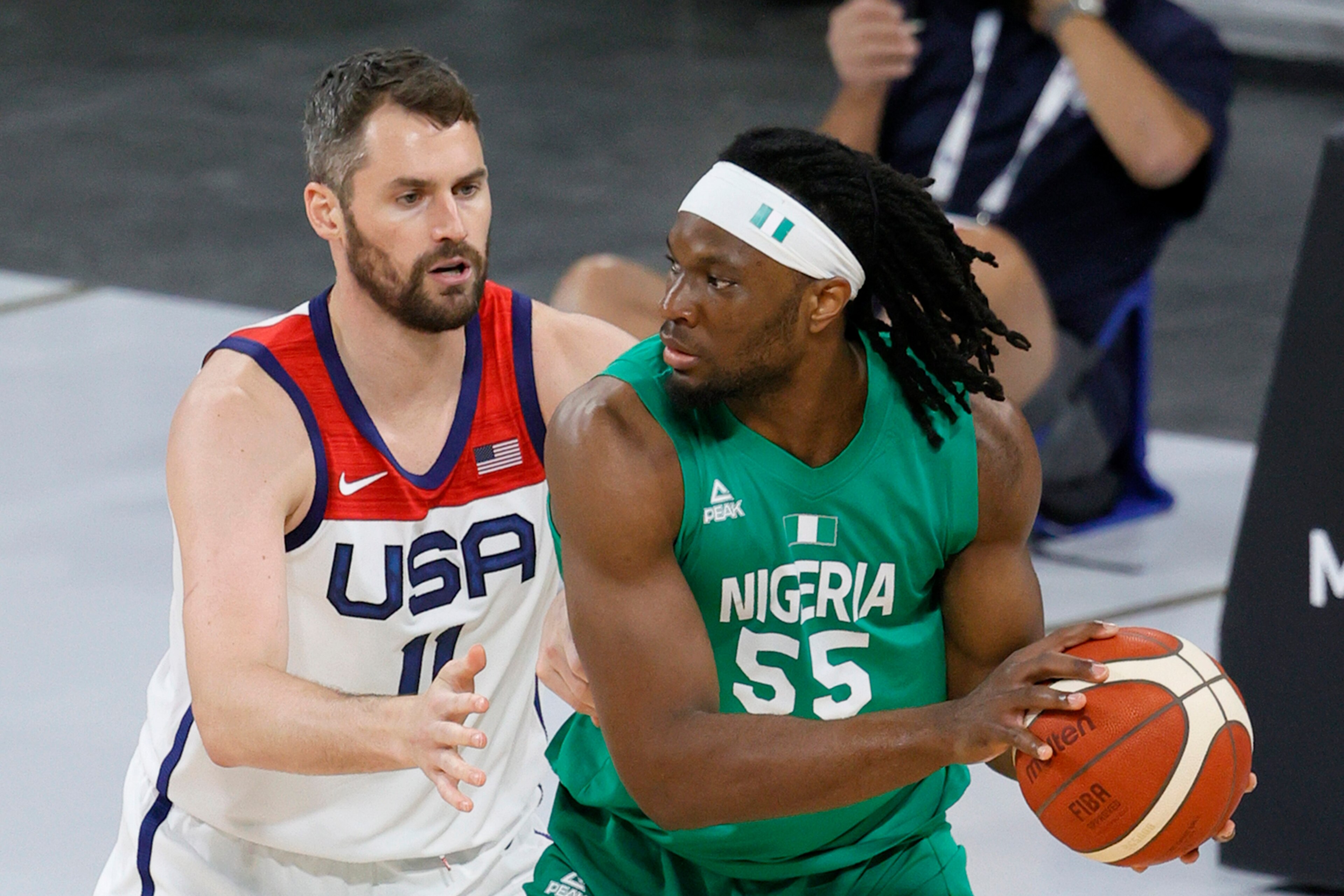 LAS VEGAS, NEVADA - JULY 10:  Precious Achiuwa #55 of Nigeria is guarded by Kevin Love #11 of the United States during an exhibition game at Michelob ULTRA Arena ahead of the Tokyo Olympic Games on July 10, 2021 in Las Vegas, Nevada. Nigeria defeated the 
