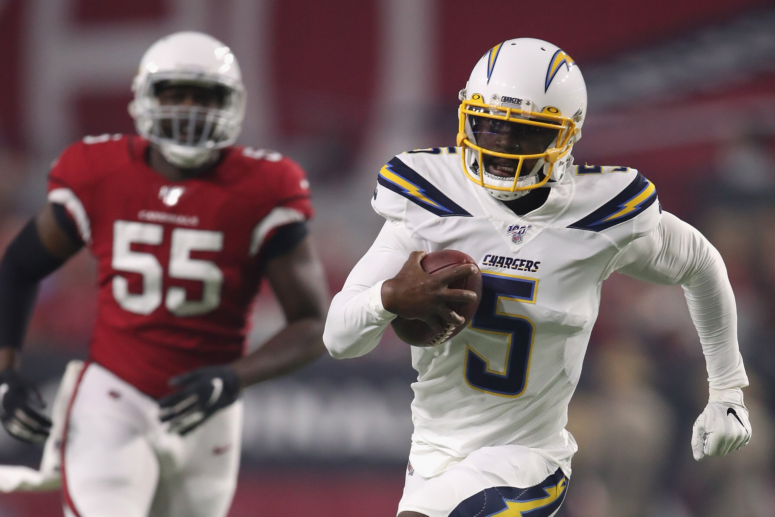 GLENDALE, ARIZONA - AUGUST 08:  Quarterback Tyrod Taylor #5 of the Los Angeles Chargers runs with the football ahead of linebacker Chandler Jones #55 of the Arizona Cardinals during the NFL preseason game at State Farm Stadium on August 08, 2019 in Glenda