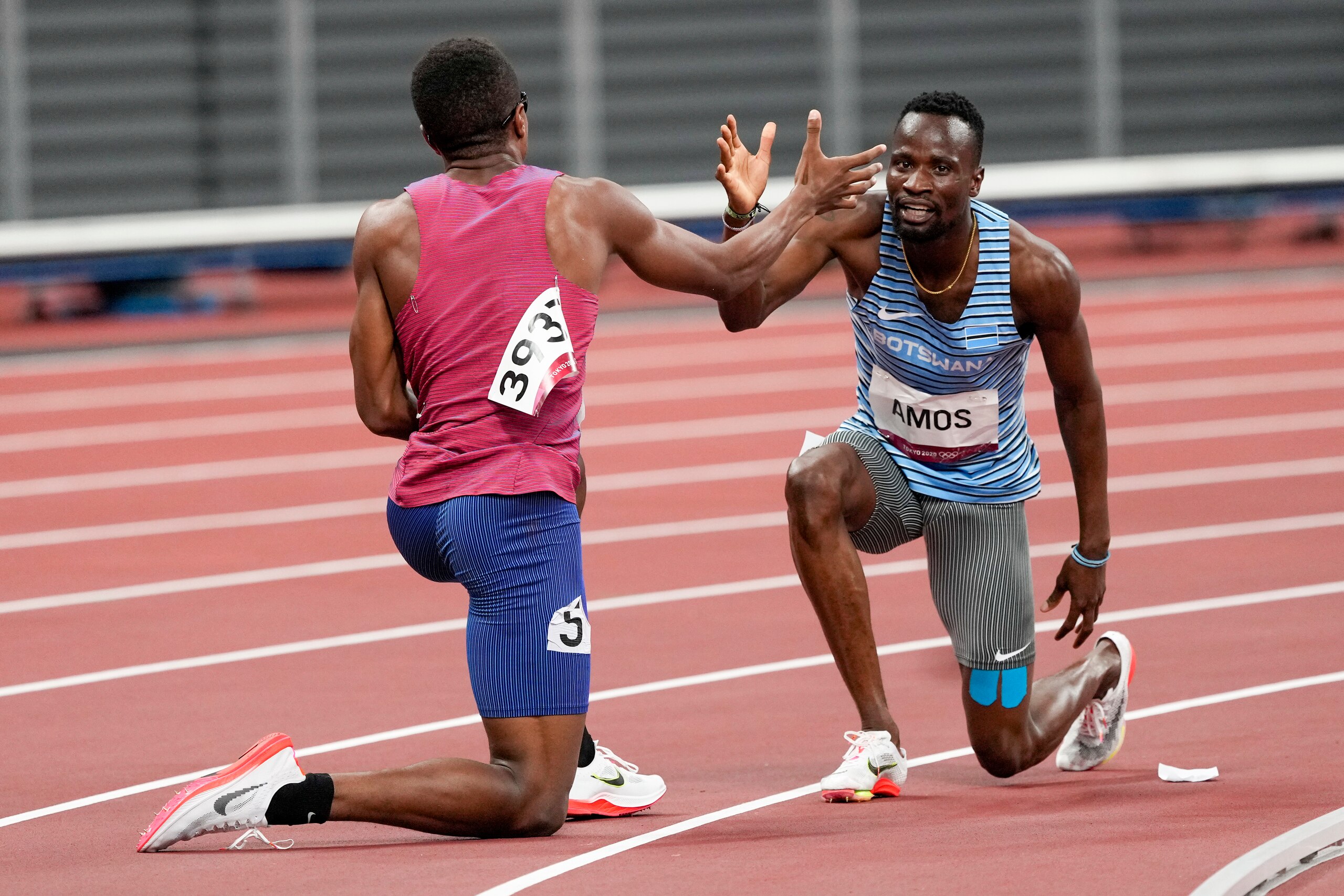 Isaiah Jewett and Nijel Amos help each other to their feet after colliding in the 800-meter race.