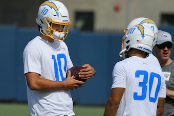 COSTA MESA, CA - JUNE 15: Justin Herbert #10 of the Los Angeles Chargers talks to Austin Ekeler #30 during mandatory minicamp on June 15, 2021 in Costa Mesa, California. (Photo by John McCoy/Getty Images)