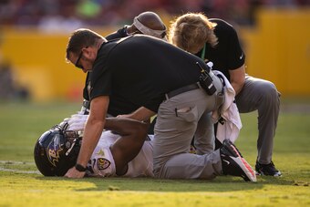 LANDOVER, MD - AUGUST 28: J.K. Dobbins #27 of the Baltimore Ravens receives attention after being injured against the Washington Football Team during the first half of a preseason game at FedExField on August 28, 2021 in Landover, Maryland. J.K. Dobbins w