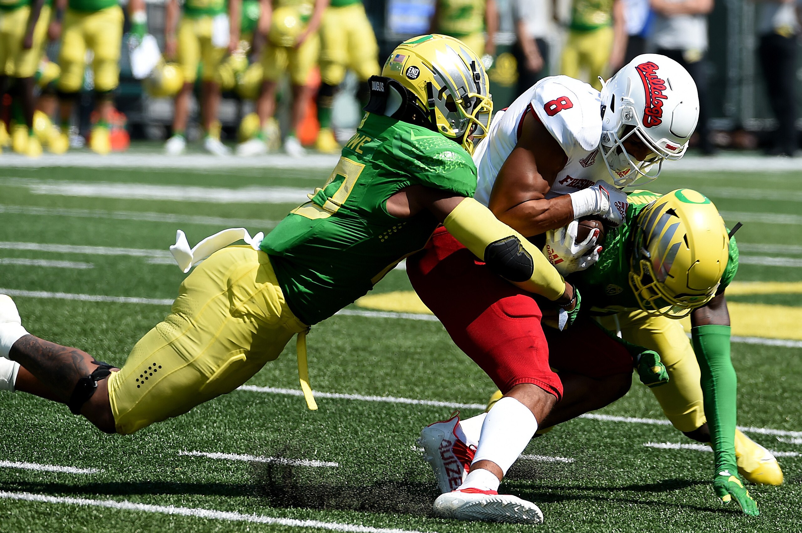 EUGENE, OREGON - SEPTEMBER 04: Linebacker Justin Flowe #10 and cornerback Dontae Manning #8 of the Oregon Ducks bring down wide receiver Ty Jones #8 of the Fresno State Bulldogs during the third quarter of the game at Autzen Stadium on September 04, 2021 