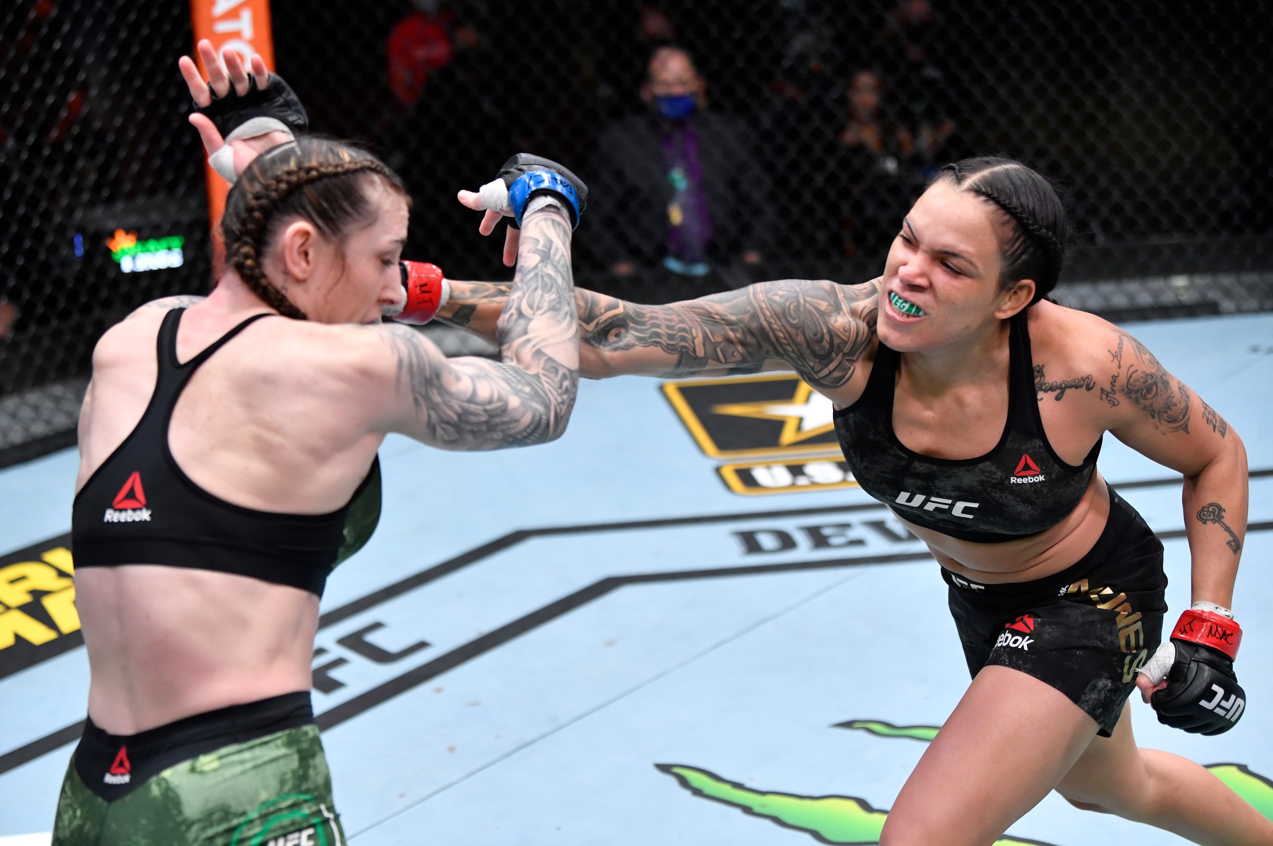 LAS VEGAS, NEVADA - MARCH 06: In this handout image provided by UFC, (R-L) Amanda Nunes of Brazil punches Megan Anderson of Australia in their UFC featherweight championship fight during the UFC 259 event at UFC APEX on March 06, 2021 in Las Vegas, Nevada
