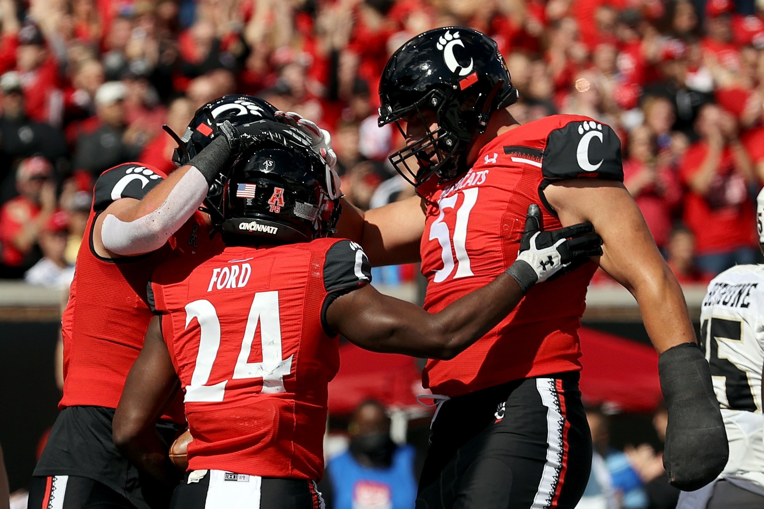 CINCINNATI, OHIO - OCTOBER 16: Jerome Ford #24 of the Cincinnati Bearcats celebrates with teammates after scoring a touchdown in the first quarter against the UCF Knights at Nippert Stadium on October 16, 2021 in Cincinnati, Ohio. (Photo by Dylan Buell/Ge CINCINNATI, OHIO - OCTOBER 16: Jerome Ford #24 of the Cincinnati Bearcats celebrates with teammates after scoring a touchdown in the first quarter against the UCF Knights at Nippert Stadium on October 16, 2021 in Cincinnati, Ohio. (Photo by Dylan Buell/Ge