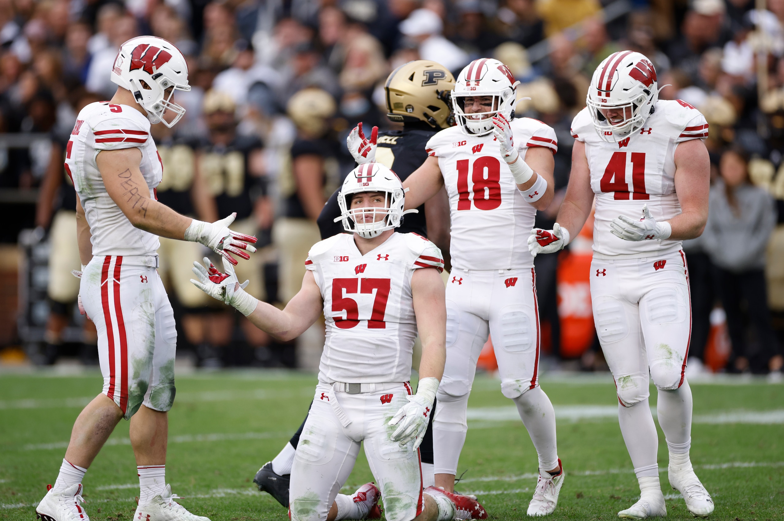 WEST LAFAYETTE, IN - OCTOBER 23: Wisconsin Badgers linebacker Jack Sanborn (57) celebrates with linebacker Leo Chenal (5), safety Collin Wilder (18) and linebacker Noah Burks (41) after defending a pass during a college football game against the Purdue Bo