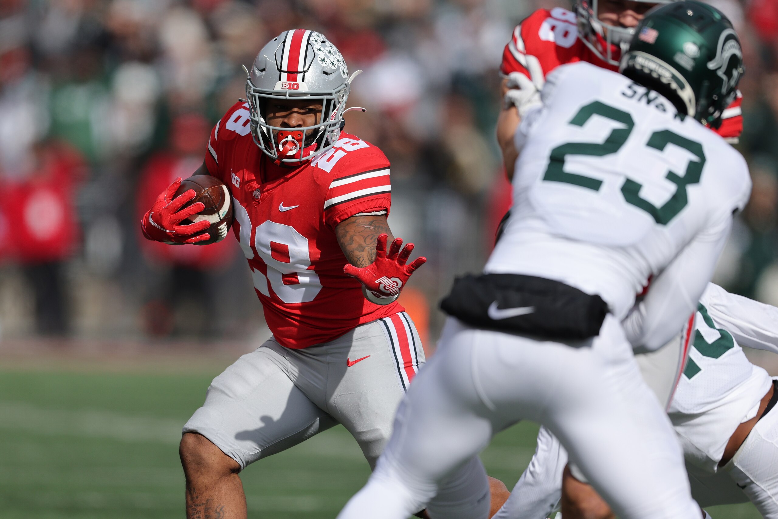 COLUMBUS, OHIO - NOVEMBER 20: Miyan Williams #28 of the Ohio State Buckeyes during a first half run against the Michigan State Spartans at Ohio Stadium on November 20, 2021 in Columbus, Ohio. (Photo by Gregory Shamus/Getty Images)