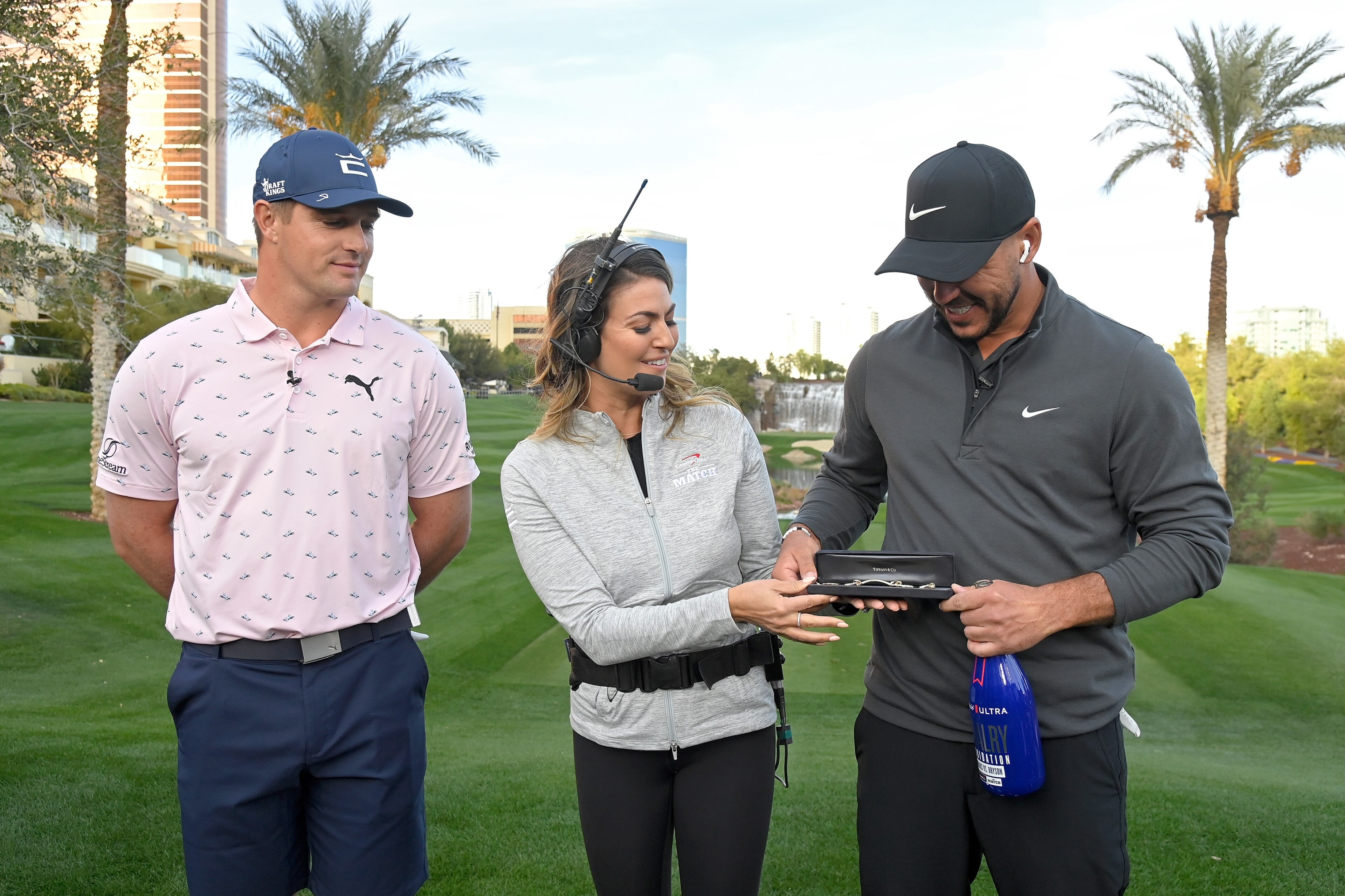 LAS VEGAS, NEVADA - NOVEMBER 26: Amanda Balionis presents Brooks Koepka (R) with a bracelet after beating Bryson DeChambeau during Capital One's The Match V: Bryson v Brooks at Wynn Golf Course on November 26, 2021 in Las Vegas, Nevada. (Photo by David Be