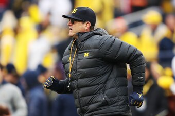 ANN ARBOR, MICHIGAN - NOVEMBER 27: Head coach Jim Harbaugh of the Michigan Wolverines runs on the field during warm-ups prior to the game against the Ohio State Buckeyes at Michigan Stadium on November 27, 2021 in Ann Arbor, Michigan. (Photo by Mike Mulho