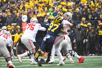 ANN ARBOR, MI - NOVEMBER 27: Ohio State Buckeyes quarterback C.J. Stroud (7) gets the ball away just before Michigan Wolverines defensive end Aidan Hutchinson (97) hits him during The Michigan Wolverines vs the Ohio State Buckeyes game on Saturday Novembe