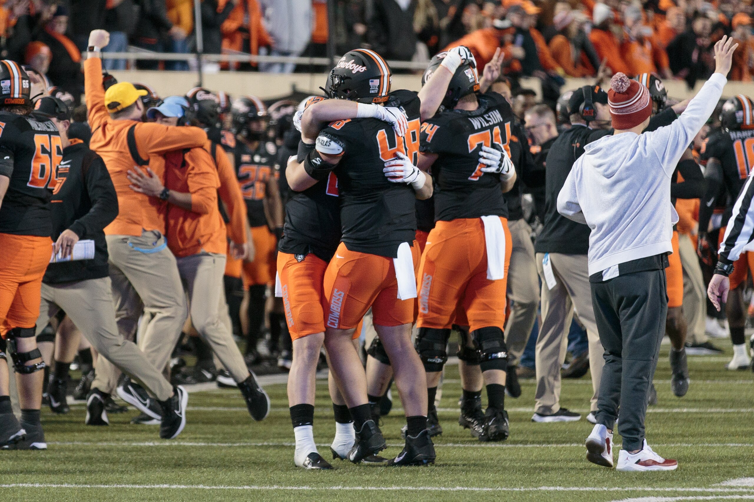 STILLWATER, OK - NOVEMBER 27: Oklahoma State Cowboys hug and celebrate the victory over the Oklahoma Sooners on November 27th, 2021 at Boone Pickens Stadium in Stillwater, Oklahoma. (Photo by William Purnell/Icon Sportswire via Getty Images)