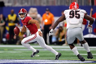 ATLANTA, GEORGIA - DECEMBER 04: Bryce Young #9 of the Alabama Crimson Tide carries the ball as Devonte Wyatt #95 of the Georgia Bulldogs defends in the second quarter of the SEC Championship game at Mercedes-Benz Stadium on December 04, 2021 in Atlanta, G