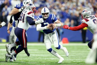 INDIANAPOLIS, INDIANA - DECEMBER 18: Carson Wentz #2 of the Indianapolis Colts scrambles as Deatrich Wise #91 of the New England Patriots defends during the second half at Lucas Oil Stadium on December 18, 2021 in Indianapolis, Indiana. (Photo by Andy Lyo