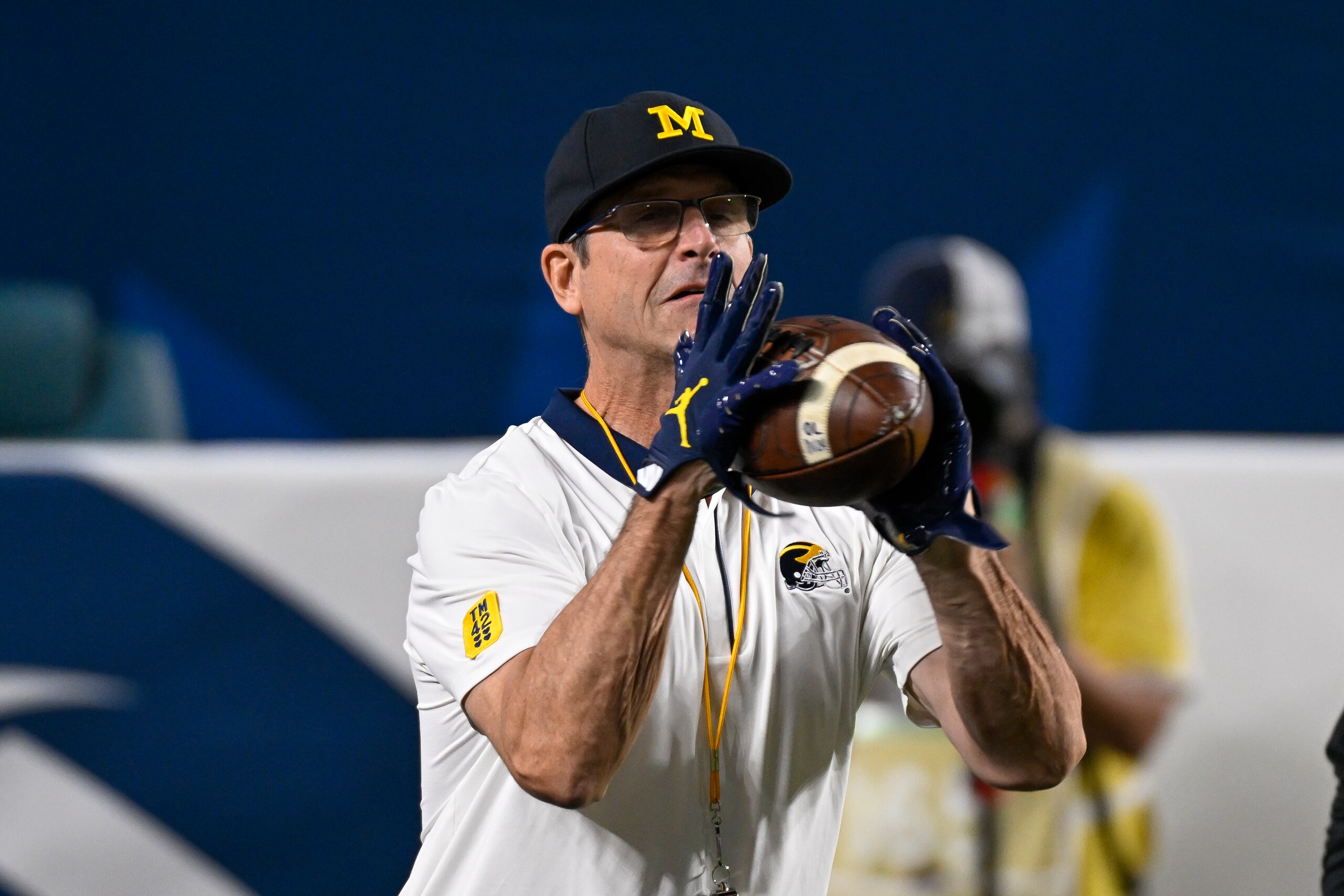 MIAMI GARDENS, FL - DECEMBER 31: Michigan Wolverines head coach Jim Harbaugh catches the ball on the field before the start of the College Football Playoff Semifinal game between the Georgia Bulldogs and the Michigan Wolverines at the Capital One Orange B