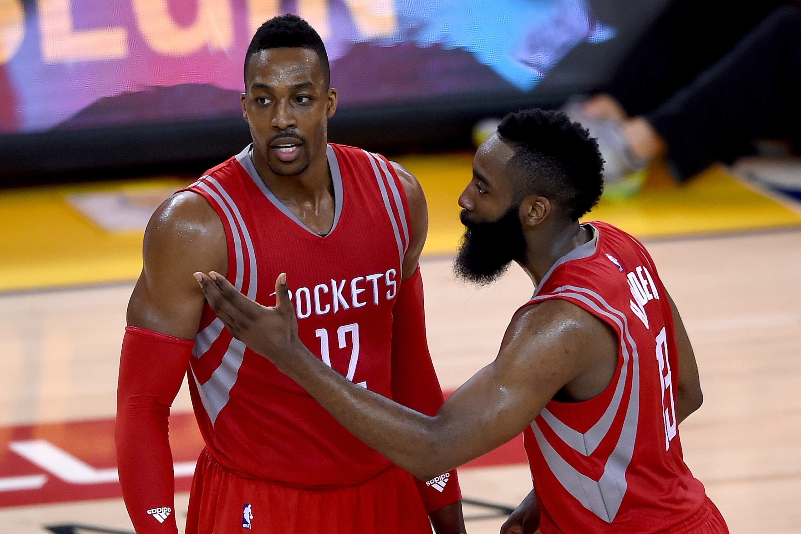 OAKLAND, CA - MAY 21:  James Harden #13 of the Houston Rockets talks with teammate Dwight Howard #12 before Howard shoots a free throw against the Golden State Warriors during the second half in Game Two of the Western Conference Finals of the NBA Playoff