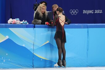 BEIJING, CHINA - FEBRUARY 17: Kamila Valieva of Team ROC talks to coaches Eteri Tutberidze (L) and Sergei Dudakov (R) during the Women Single Skating Free Skating on day thirteen of the Beijing 2022 Winter Olympic Games at Capital Indoor Stadium on Februa