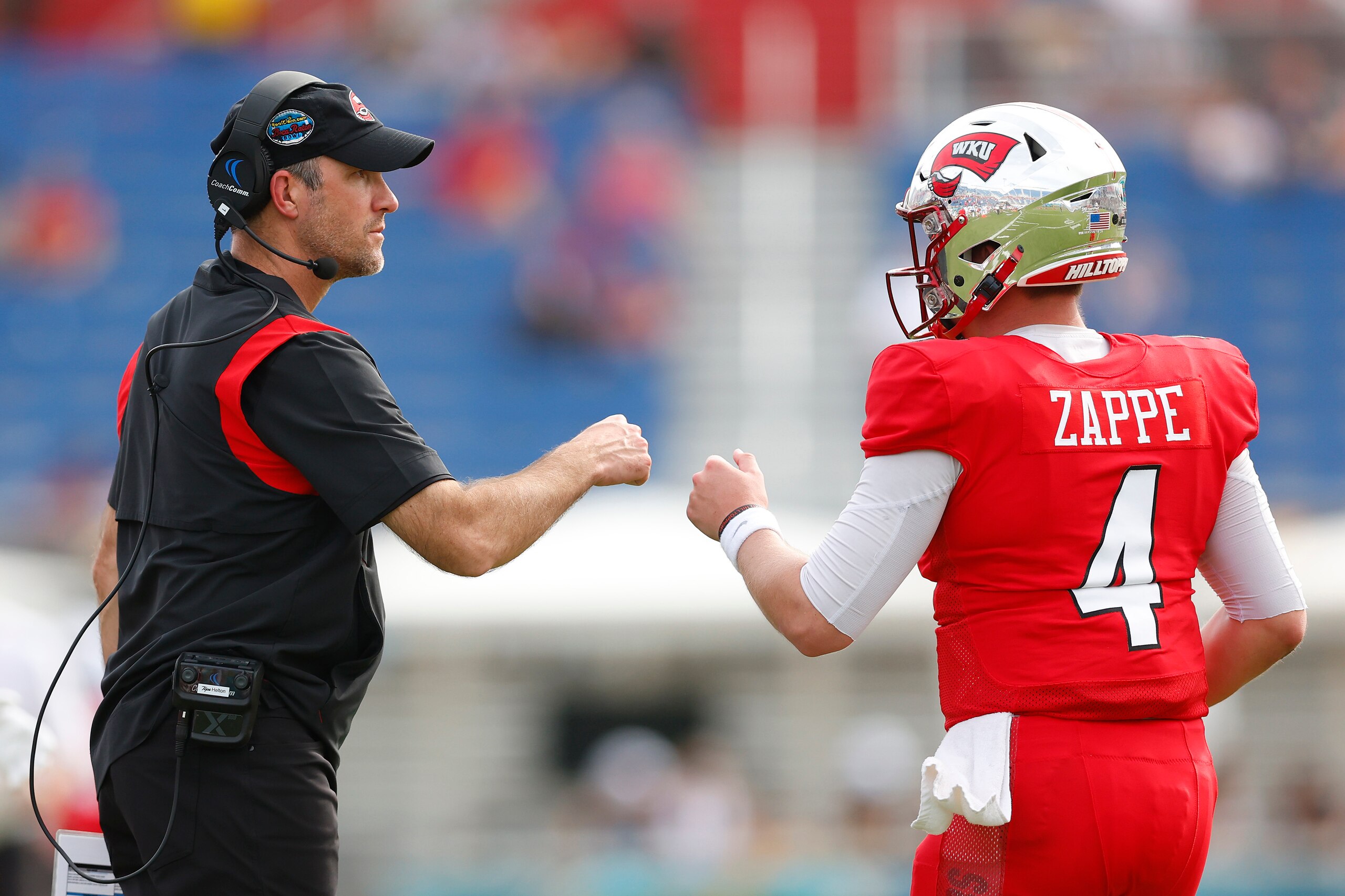 BOCA RATON, FLORIDA - DECEMBER 18: Head coach Tyson Helton of the Western Kentucky Hilltoppers fist bumps Bailey Zappe #4 against the Appalachian State Mountaineers during the second half of the RoofClaim.com Boca Raton Bowl at FAU Stadium on December 18,