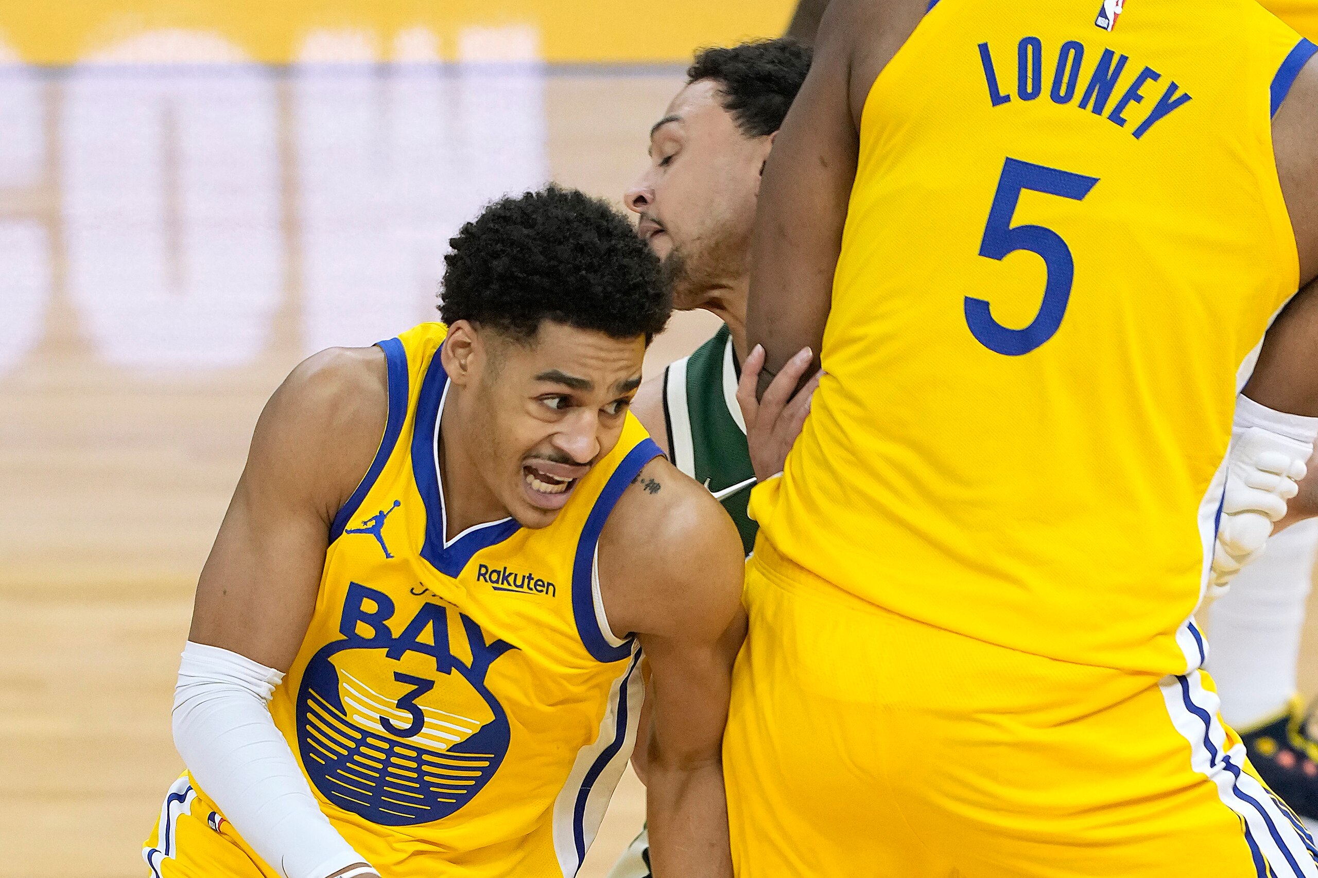 SAN FRANCISCO, CALIFORNIA - APRIL 06: Jordan Poole #3 of the Golden State Warriors dribbles around a screen set by Kevon Looney #5 on Bryn Forbes #7 of the Milwaukee Bucks during the first half of an NBA basketball game at Chase Center on April 06, 2021 i