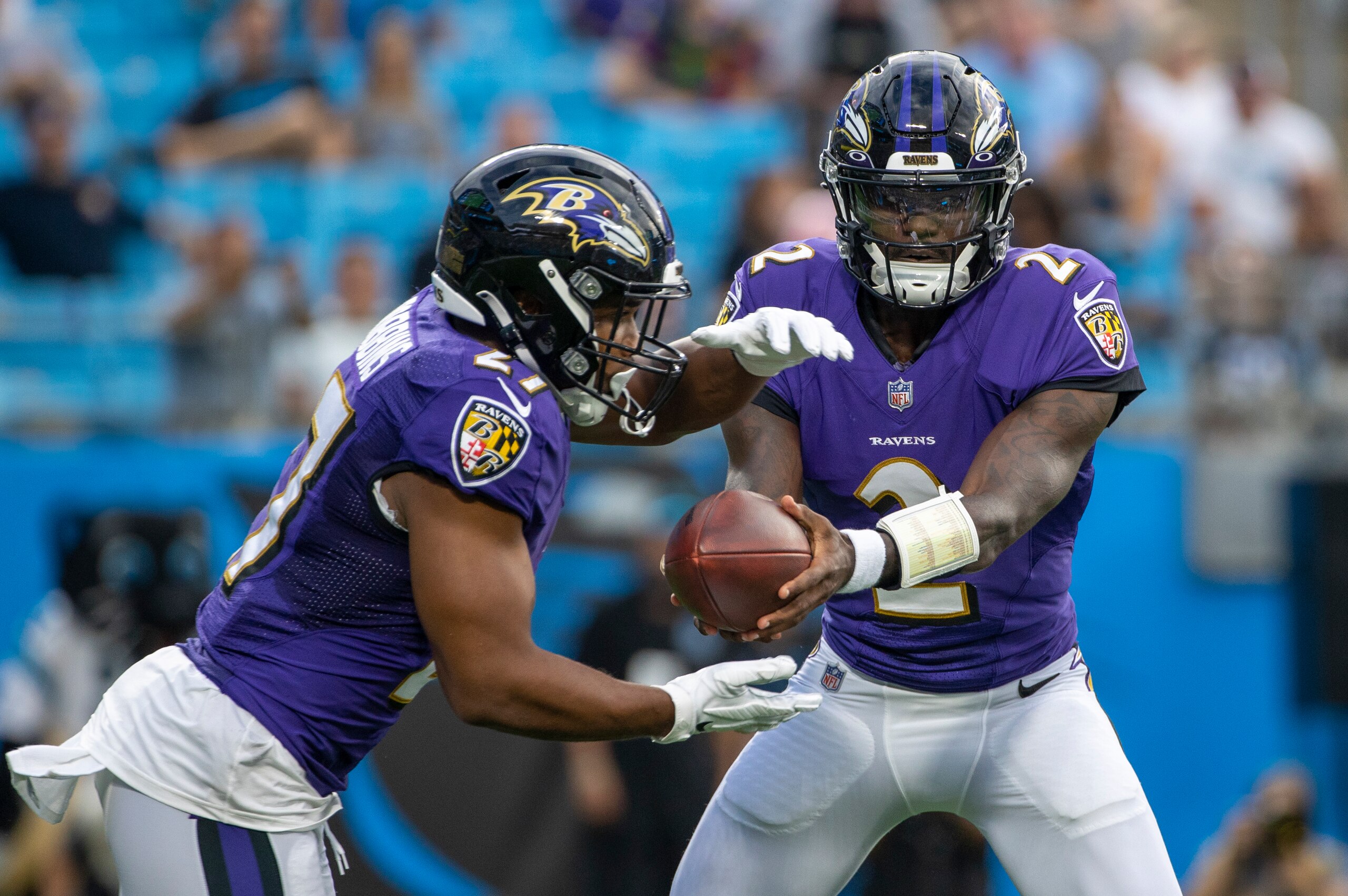 CHARLOTTE, NC - AUGUST 21: Tyler Huntley #2 of the Baltimore Ravens hands the ball off to J.K. Dobbins #27 against the Carolina Panthers during the first half of a NFL preseason game at Bank of America Stadium on August 21, 2021 in Charlotte, North Caroli