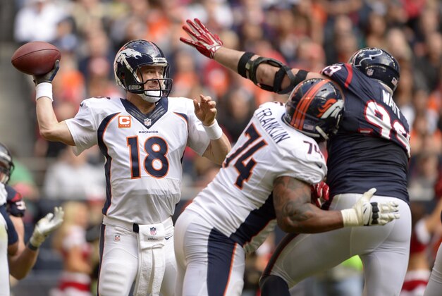 Dec 22, 2013; Houston, TX, USA; Denver Broncos quarterback Peyton Manning (18) passes while being rushed by Houston Texans defensive end J.J. Watt (99) during the second half at Reliant Stadium. The Broncos won 37-13. Mandatory Credit: Thomas Campbell-USA TODAY Sports
