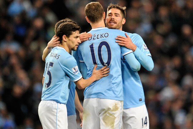 MANCHESTER, ENGLAND - DECEMBER 28:  Edin Dzeko of Manchester City is congratulated by team-mates Javi Garcia (r) and Jesus Navas (l)  during the Barclays Premier League match between Manchester City and Crystal Palace at the Etihad Stadium on December 28, 2013 in Manchester, England.  (Photo by Clint Hughes/Getty Images)