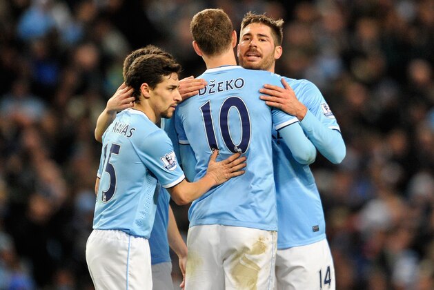 MANCHESTER, ENGLAND - DECEMBER 28:  Edin Dzeko of Manchester City is congratulated by team-mates Javi Garcia (r) and Jesus Navas (l)  during the Barclays Premier League match between Manchester City and Crystal Palace at the Etihad Stadium on December 28, 2013 in Manchester, England.  (Photo by Clint Hughes/Getty Images)