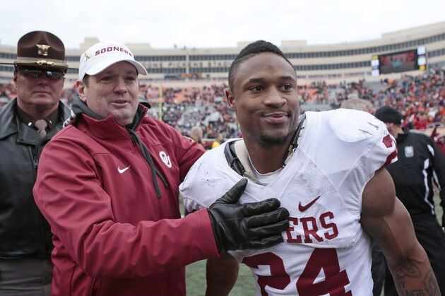 STILLWATER, OK - DECEMBER 7:    Head coach Bob Stoops congratulates running back Brennan Clay #24 of the Oklahoma Sooners after the game against the Oklahoma State Cowboys December 7, 2013 at Boone Pickens Stadium in Stillwater, Oklahoma. Oklahoma defeated Oklahoma State 33-24. (Photo by Brett Deering/Getty Images)