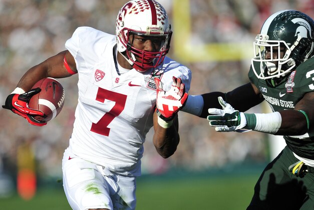 January 1, 2014; Pasadena, CA, USA; Stanford Cardinal wide receiver Ty Montgomery (7) runs the ball against the defense of Michigan State Spartans cornerback Trae Waynes (15) during the first half at Rose Bowl. Mandatory Credit: Gary A. Vasquez-USA TODAY Sports